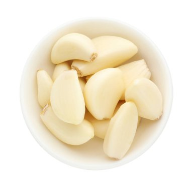 Taze sarımsak karanfilleri beyaz kasede izole edilmiş.