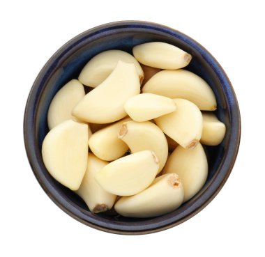 Taze sarımsak karanfilleri beyaz kasede izole edilmiş.