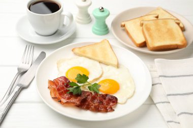 Beyaz ahşap masada servis edilen yağda yumurta ve pastırmalı nefis bir kahvaltı.