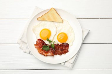 Beyaz ahşap masada servis edilen omlet ve pastırmalı nefis bir kahvaltı.