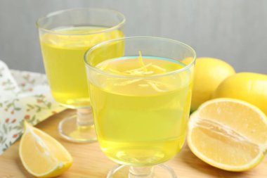 Tatlı kaselerinde leziz sarı jöle ve masada limon, yakın plan.
