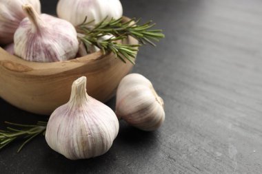 Siyah masada taze sarımsak soğanı ve biberiye, yakın plan. Metin için boşluk