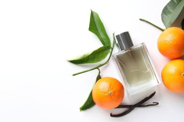 Beyaz arka planda bir şişe parfüm, mandalina ve vanilya. Metin için boşluk