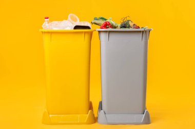 Çöp tenekeleri turuncu arka planda. Atık sıralama
