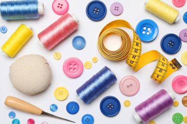 Beyaz zemin üzerinde dikiş malzemeleri ile düz bileşim yatıyordu