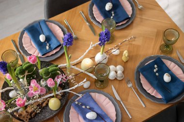 Paskalya kutlaması. Çiçekli şenlik masası ve kapalı alanda yumurtalar, düzlük.