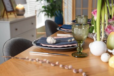 Paskalya kutlaması. Çiçekli şenlik masası ve kapalı mekanda yumurtalar, yakın plan.