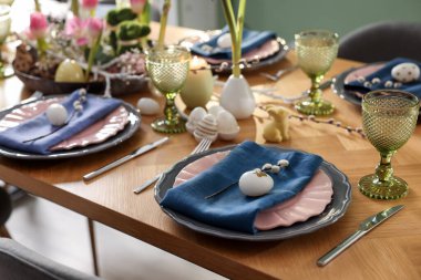 Paskalya kutlaması. Çiçekli şenlik masası ve kapalı mekanda yumurtalar, yakın plan.