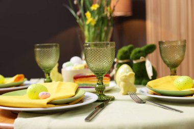 Paskalya kutlaması. Zarif bulaşık takımları ve boyalı yumurtalarla şenlik masası, yakın plan.