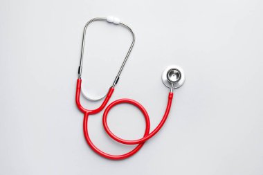Açık gri arkaplanda kırmızı steteskop, üst görünüm