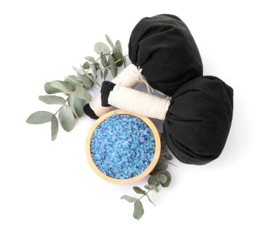 Kasede mavi deniz tuzu, bitkisel torbalar ve okaliptüs dalları beyaz, üst görünümde izole.