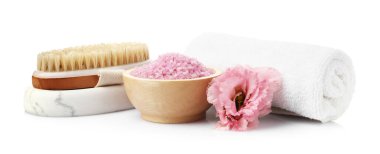 Kasedeki pembe deniz tuzu, fırça, havlu ve çiçek beyaza izole edilmiş.