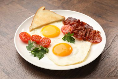 Yağda yumurta ve pastırma ile nefis bir kahvaltı, ahşap masada servis edilir, yakın plan.