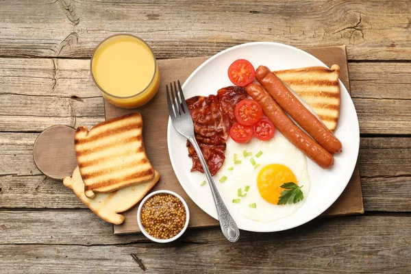 Tahta masada servis edilen kızarmış yumurta, sosis ve domuz pastırması ile nefis bir kahvaltı.