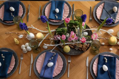 Paskalya kutlaması. Çiçekli şenlik masası ve kapalı alanda yumurtalar, düzlük.