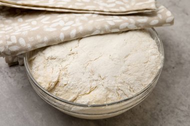 Gri desenli masada cam kasede taze maya hamuru, yakın plan.