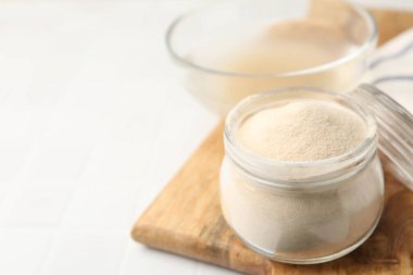 Cam kavanozdaki jelatin tozu ışık masasının üzerinde, yakın plan. Metin için boşluk