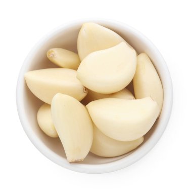 Taze sarımsak karanfilleri beyaz kasede izole edilmiş.