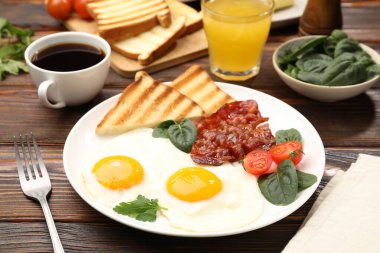 Yağda yumurta ve pastırma ile nefis bir kahvaltı, ahşap masada servis edilir, yakın plan.