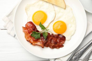 Beyaz ahşap masada servis edilen omlet ve pastırmayla nefis bir kahvaltı.