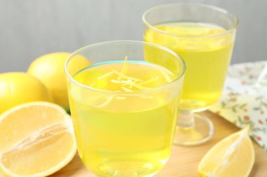 Tatlı kaselerinde leziz sarı jöle ve masada limon, yakın plan.