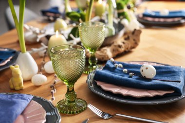 Paskalya kutlaması. Çiçekli şenlik masası ve kapalı mekanda yumurtalar, yakın plan.