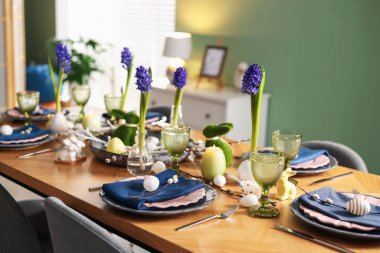 Paskalya kutlaması. Çiçeklerle süslü masa ve kapalı alanda yumurtalar.