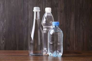 Tahta masada farklı boyutlarda su şişeleri var.