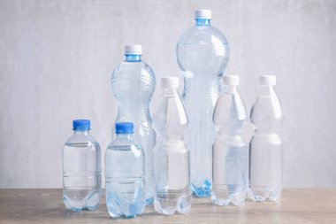 Tahta masada farklı boyutlarda su şişeleri var.