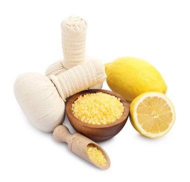 Sarı deniz tuzu, kepçe, bitkisel torbalar ve limonlar beyaza izole edilmiş.