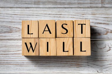 Son vasiyet. Tahta masanın üstünde harflerle yazılmış küplerden yapılmış kelimeler.