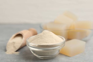 Jelatin tozu ve jöle küpleri gri masada, yakın plan.