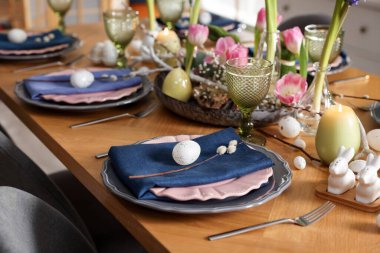 Paskalya kutlaması. Çiçekli şenlik masası ve kapalı mekanda yumurtalar, yakın plan.