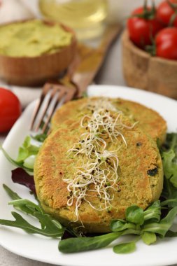 Mikroyeşillikli lezzetli vejetaryen köfteler ve gri masada salata, yakın plan.