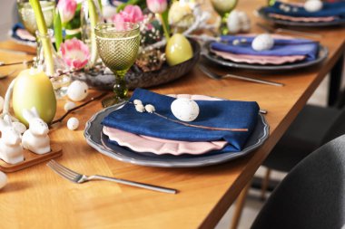 Paskalya kutlaması. Çiçekli şenlik masası ve kapalı mekanda yumurtalar, yakın plan.