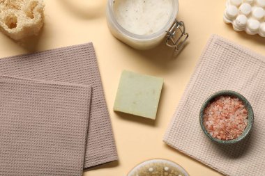 Temiz waffle havluları ve bej arka planda kişisel bakım ürünleri.