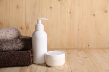 Temiz havlular ve kozmetik ürünler ahşap masada. Metin için boşluk