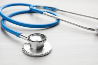 Mavi steteskop açık ahşap masada, yakın plan.