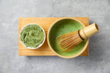 Seramik kasede taze yeşil kibrit, gri desenli masada bambu çırpı ve toz, üst manzara