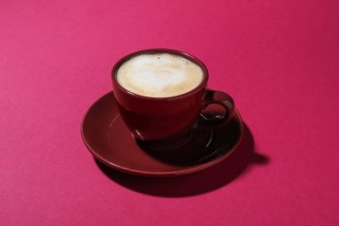 Kırmızı arka planda bir fincan aromatik kahve, yakın plan.