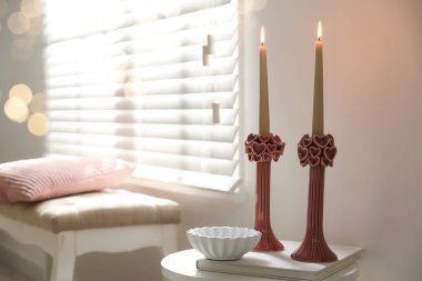 Beyaz masa üzerinde yanan mumlar olan zarif şamdanlar, metin için yer.