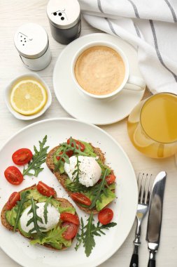 Avokado tostları ve hafif ahşap masada servis edilen haşlanmış yumurtalarla nefis bir kahvaltı.