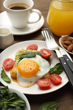 Tahta masada servis edilen avokado tostlu sağlıklı bir kahvaltı.