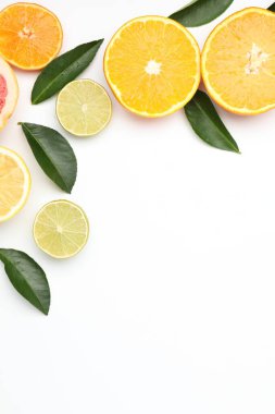 Farklı taze narenciye meyveleri ve beyaz arka planda yeşil yapraklar. Metin için boşluk