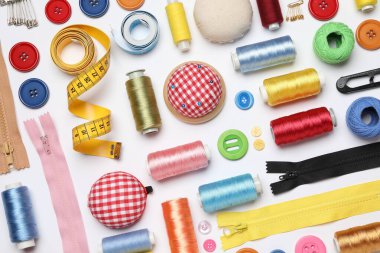 Beyaz zemin üzerinde dikiş malzemeleri ile düz bileşim yatıyordu