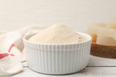 Agar-agar tozu kasede ve jöle küpleri beyaz ahşap masada, yakın plan