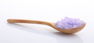 Tahta kaşıkta mor deniz tuzu. Beyaz kaşıkta izole edilmiş.