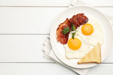 Beyaz ahşap masada servis edilen omlet ve pastırmalı nefis bir kahvaltı. Metin için boşluk