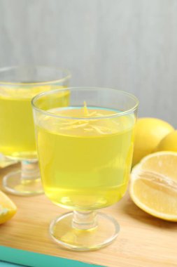 Tatlı kaselerinde leziz sarı jöle ve masada limon, yakın plan.