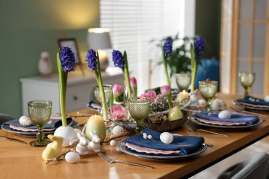 Paskalya kutlaması. Çiçeklerle süslü masa ve kapalı alanda yumurtalar.